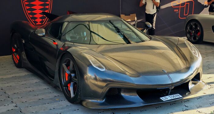 High-speed record-breaking car with carbon fiber body and aerodynamic design showcased at an auto event.