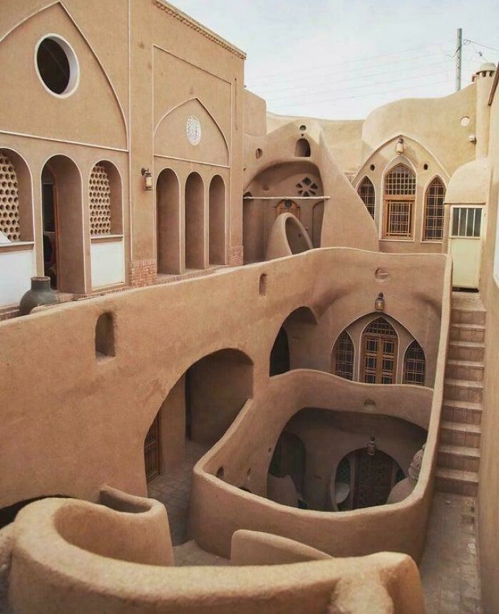 Ancient adobe architecture with unique arches and stairs showcasing smart and cool designer creativity in building structure.