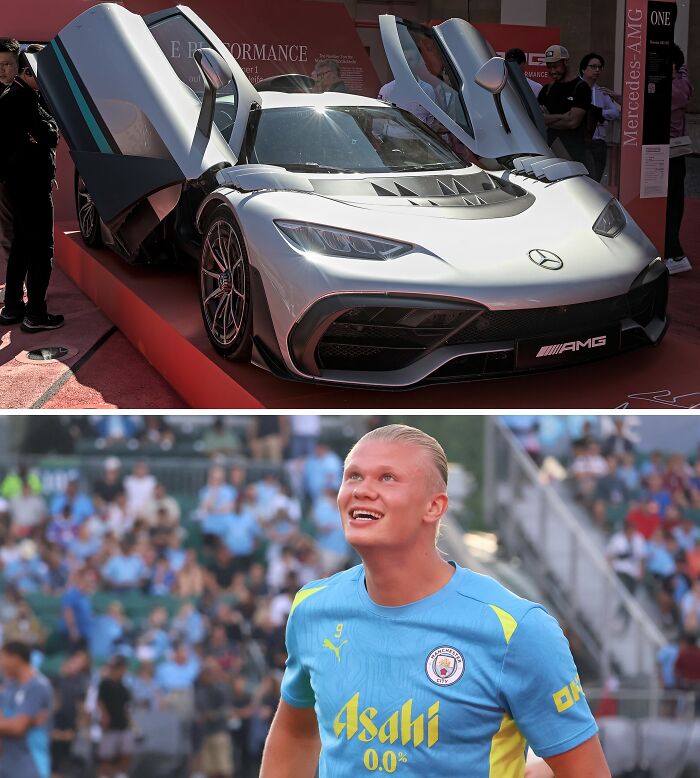 Silver Mercedes AMG sports car with butterfly doors open displayed at a football event with fans in the background.