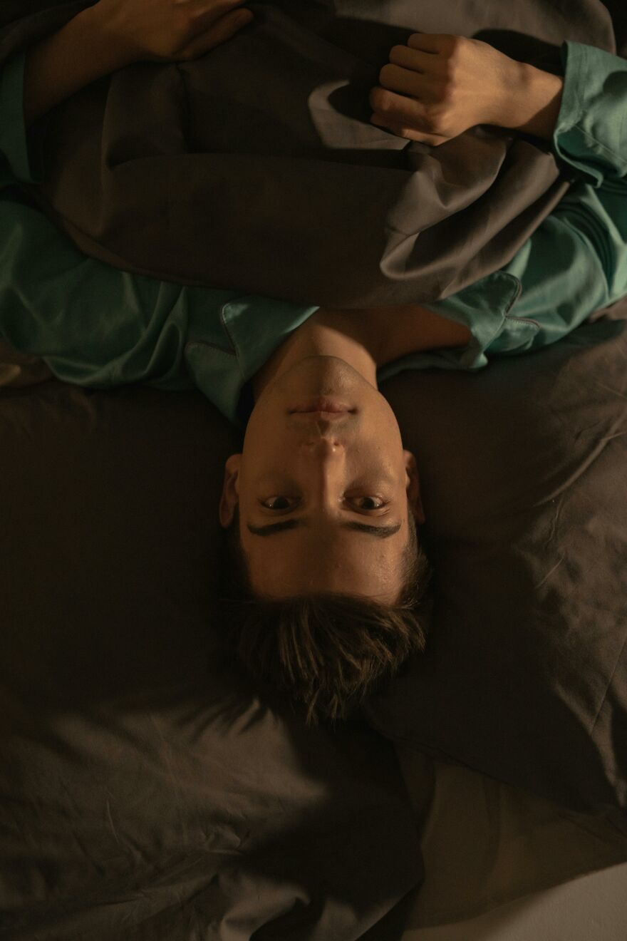Young man lying awake in bed at night, showing signs soul ties still grip with a troubled expression. Young man lying awake in bed at night, showing signs soul ties still grip with a troubled expression.