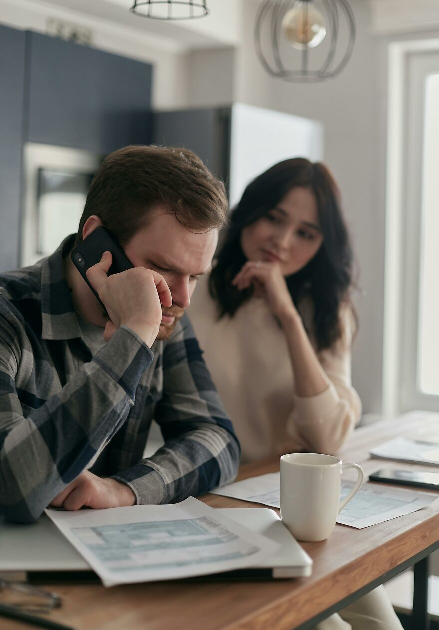 Man on phone looking stressed while woman watches him, illustrating unsettling signs of soul ties affecting relationships. Man on phone looking stressed while woman watches him, illustrating unsettling signs of soul ties affecting relationships.