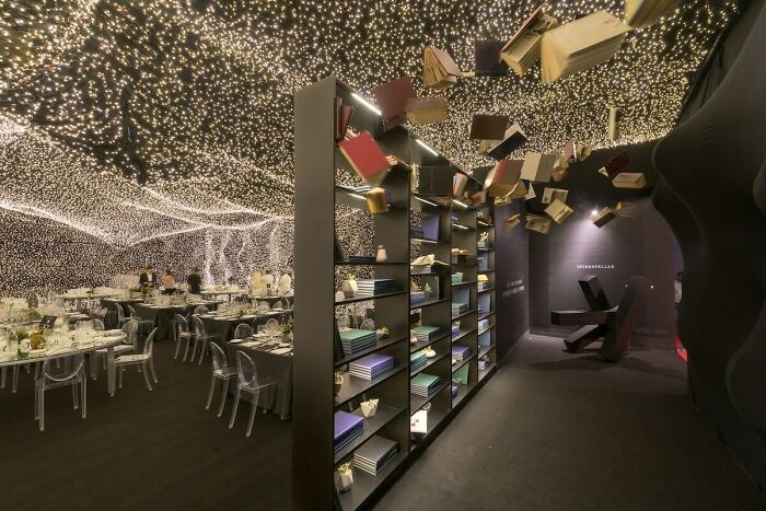 Creative bar and restaurant interior with floating books and ceiling lights, showcasing innovative design worldwide.
