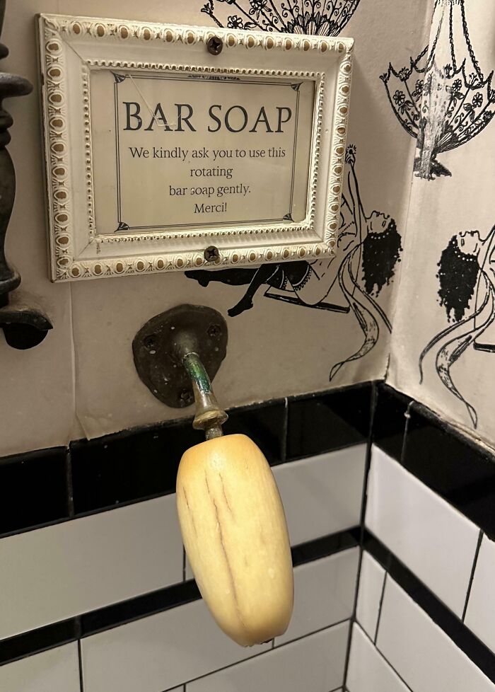Rotating bar soap fixture with vintage sign in a creatively designed bathroom at bars and restaurants.