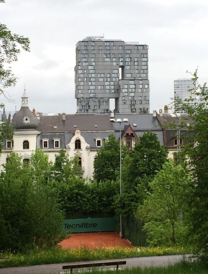Old versus modern architecture contrast with historic buildings in foreground and contemporary skyscraper in background.
