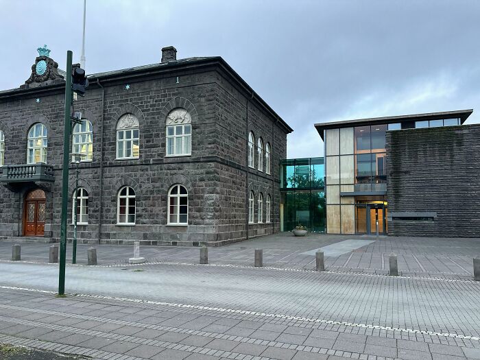 Old versus modern architecture side by side, showcasing contrasting styles with stone and glass building materials.