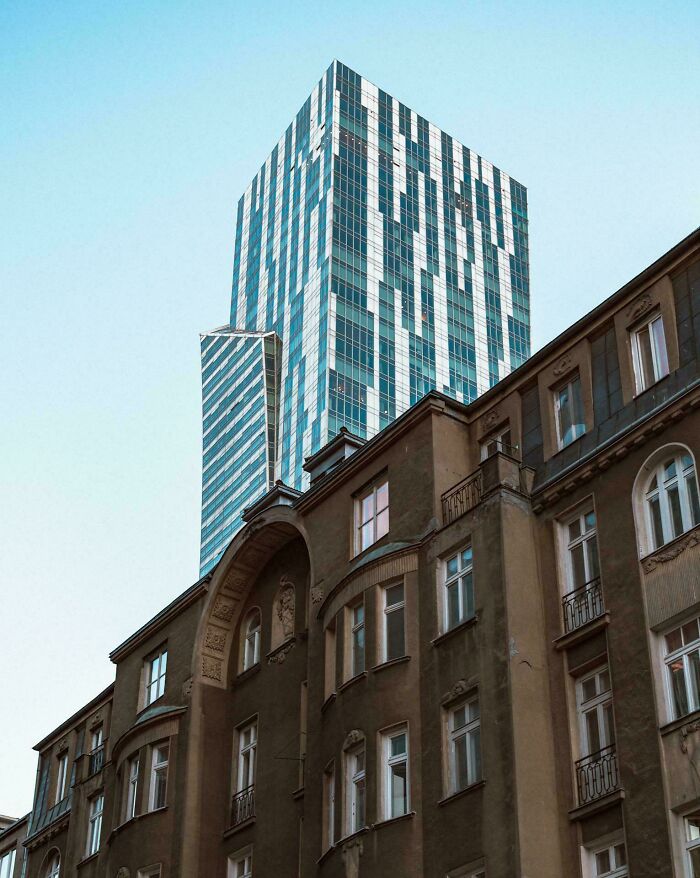 Old versus modern architecture showing contrast between an old ornate building and a sleek glass skyscraper.