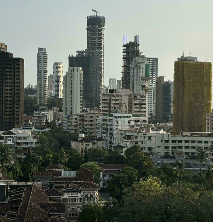 Old versus modern architecture shown in cityscape with older low-rise buildings in foreground and modern skyscrapers in background.