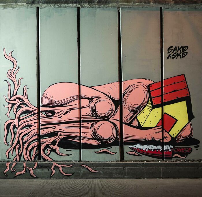 Mural by Colombian artist SakoAsko depicting a surreal blend of fantasy and reality with vibrant colors on a wall.