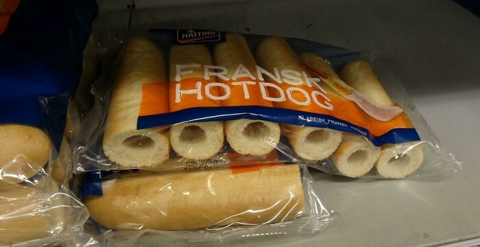 Packaged Danish hotdog buns arranged on a shelf, highlighting simple food items in a Danish prison cell setting.