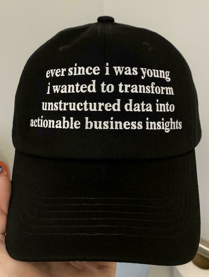 Black baseball cap with white text about transforming unstructured data into actionable business insights, programming humor.