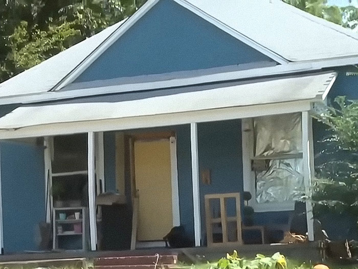 Blue house exterior with porch and open door, related to stepdad and mom felony charges after home childbirth by 11-year-old. Blue house exterior with porch and open door, related to stepdad and mom felony charges after home childbirth by 11-year-old.