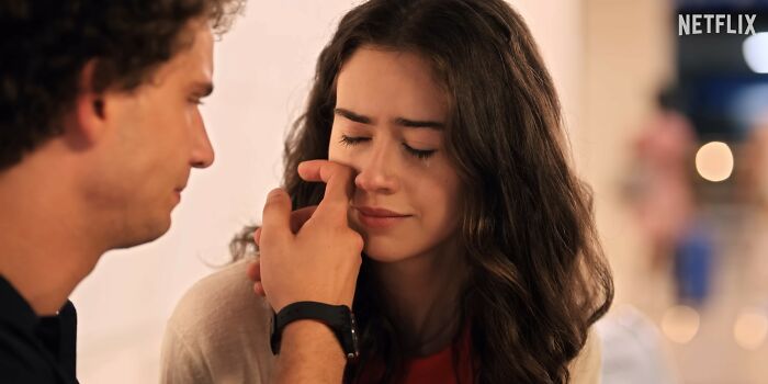 A man gently touching a woman's face in a close moment from a disappointing Netflix movie scene. A man gently touching a woman's face in a close moment from a disappointing Netflix movie scene.
