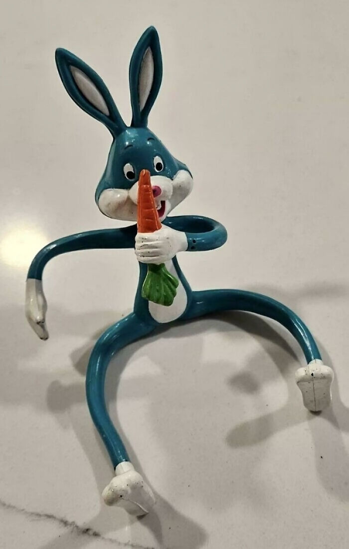 90s nostalgic toy figure of a blue rabbit holding a carrot, representing simpler and stranger days of the decade
