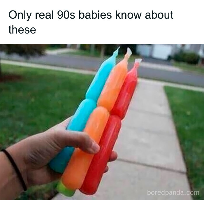 Hand holding colorful frozen ice pops outdoors, evoking 90s kids nostalgia and childhood summer memories.