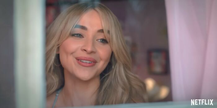 Young woman with blonde hair smiling softly in a cozy room, related to Netflix movies that were letdowns. Young woman with blonde hair smiling softly in a cozy room, related to Netflix movies that were letdowns.