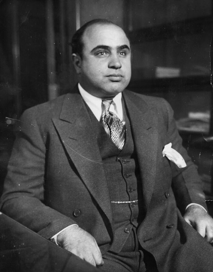 Portrait of a notorious mob boss dressed in a suit, representing one of the most infamous mob bosses in history.