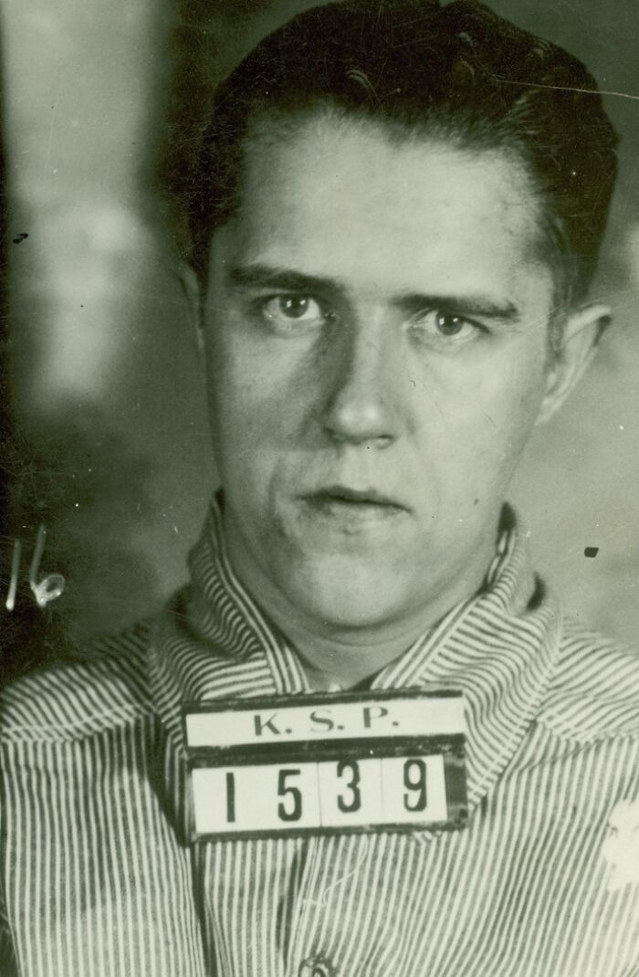 Black and white mugshot of a prisoner wearing striped uniform, illustrating the harsh reality of life on Alcatraz prison.