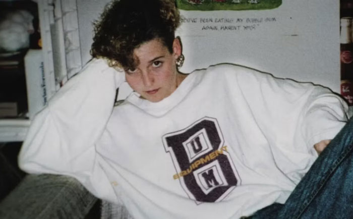 Young woman wearing a white sweatshirt with a logo, posing casually while revealing overlooked detail in Amy Bradley cruise mystery. Young woman wearing a white sweatshirt with a logo, posing casually while revealing overlooked detail in Amy Bradley cruise mystery.