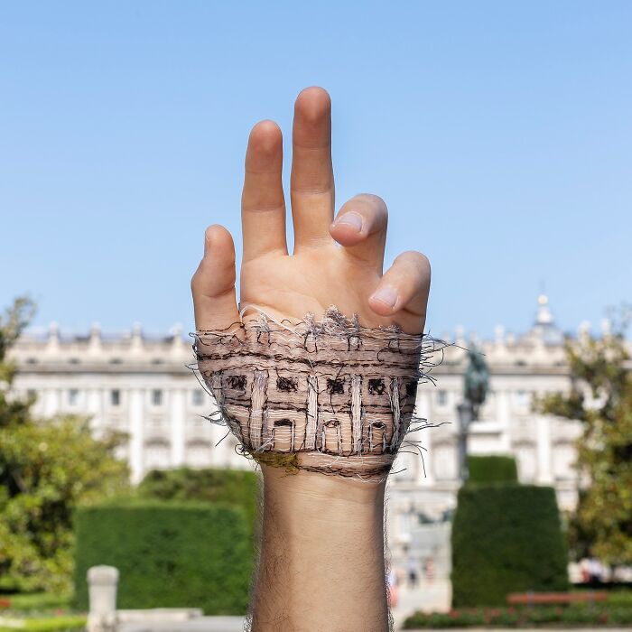 Hand with a detailed landscape stitched onto the skin, showcasing artistic embroidery blending with the natural backdrop.