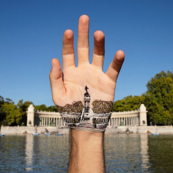 Hand with a detailed landscape stitched onto the skin, showcasing unique body art and intricate embroidery craftsmanship.