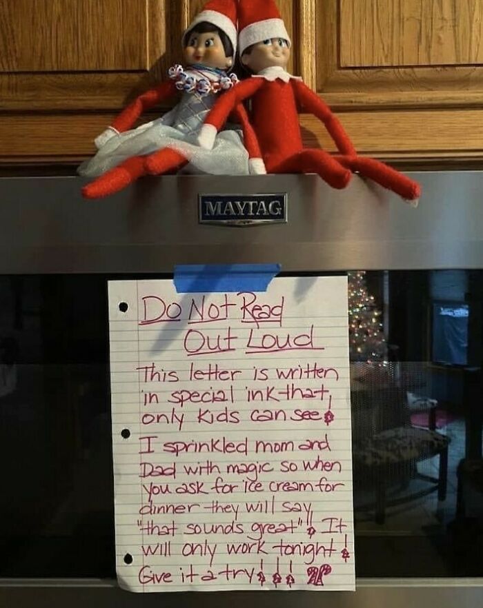 Two elf dolls sitting on a kitchen appliance with a crafty handwritten note taped below, showcasing ingenious crafty ideas.
