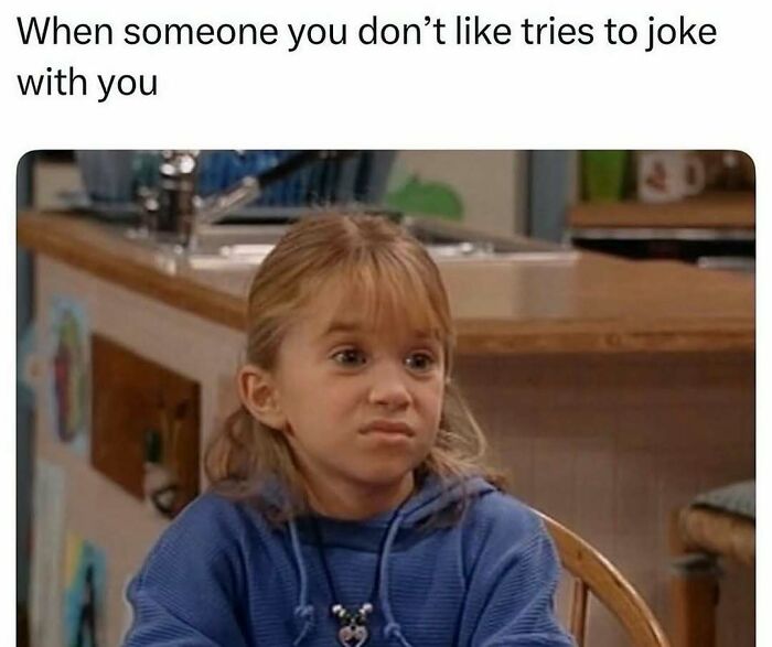 Girl sitting at a table with a disgusted face, illustrating introvert-worthy memes about social discomfort and awkwardness.