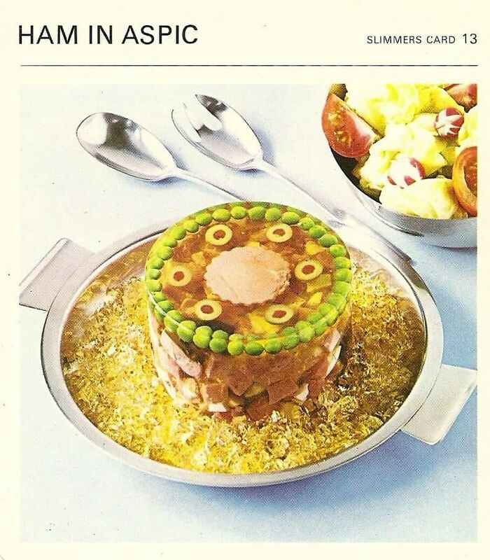 Vintage ham in aspic mold on a plate with two spoons and a salad bowl, reflecting June Cleavers vintage closet era style.