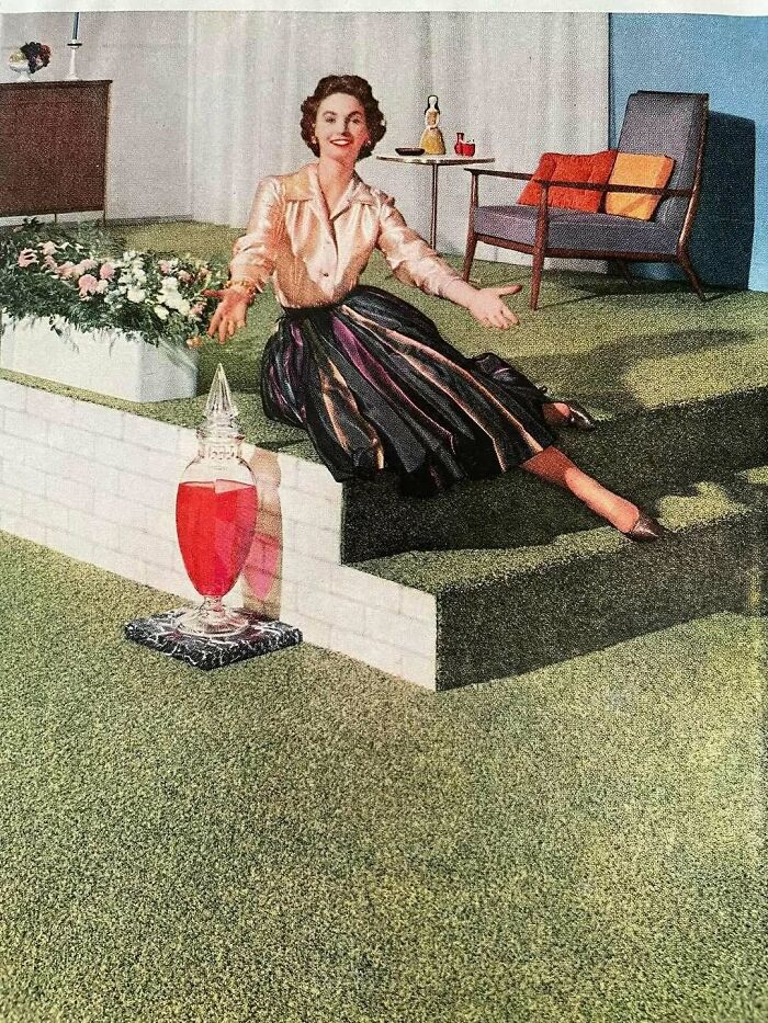 Woman in vintage clothing sitting on stairs in a mid-century living room, evoking June Cleavers vintage closet style.
