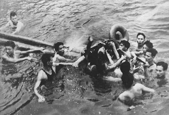 Group of men in water participating in a historical rescue, highlighting emotional moments in historical photos and backstories