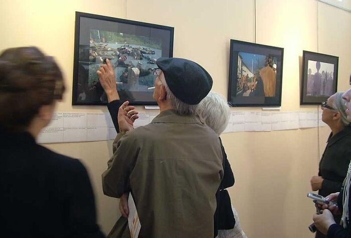 People viewing and discussing historical photos displayed on a gallery wall, highlighting captivating historical photos.