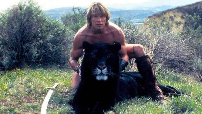 Man in medieval attire sitting behind a black panther in nature, illustrating videos with hidden context.