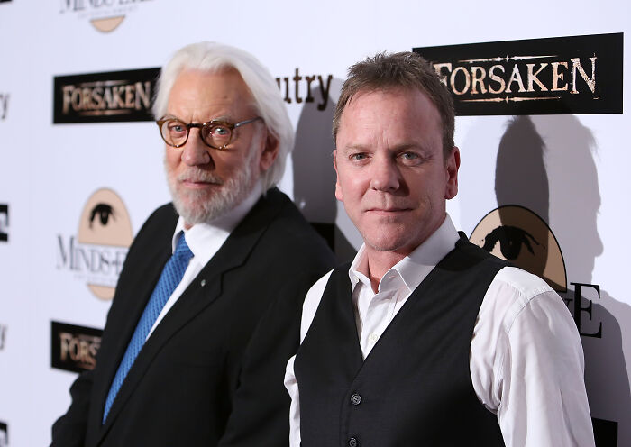 Two men posing at a red carpet event, representing legendary entertainment families passing the spotlight through generations.