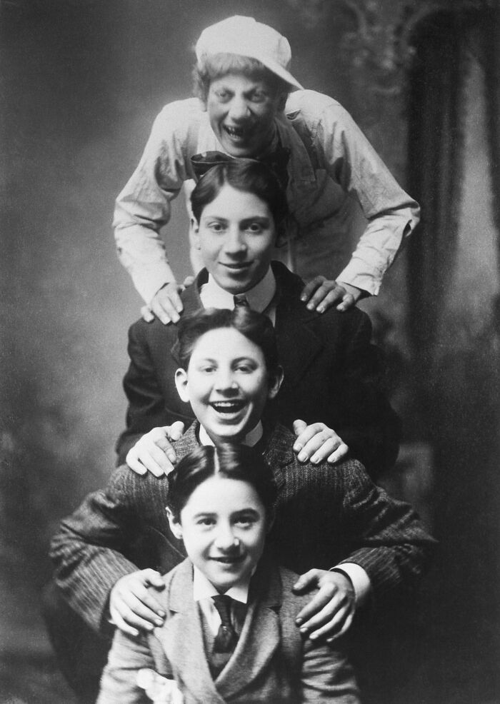 Four young men stacked vertically with hands on each other's shoulders, representing legendary entertainment families.