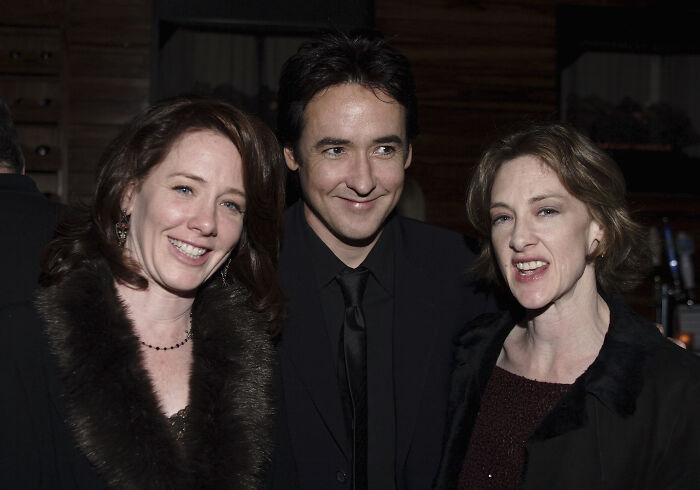 Three smiling people dressed formally at an event, representing legendary entertainment families passing the spotlight through generations.