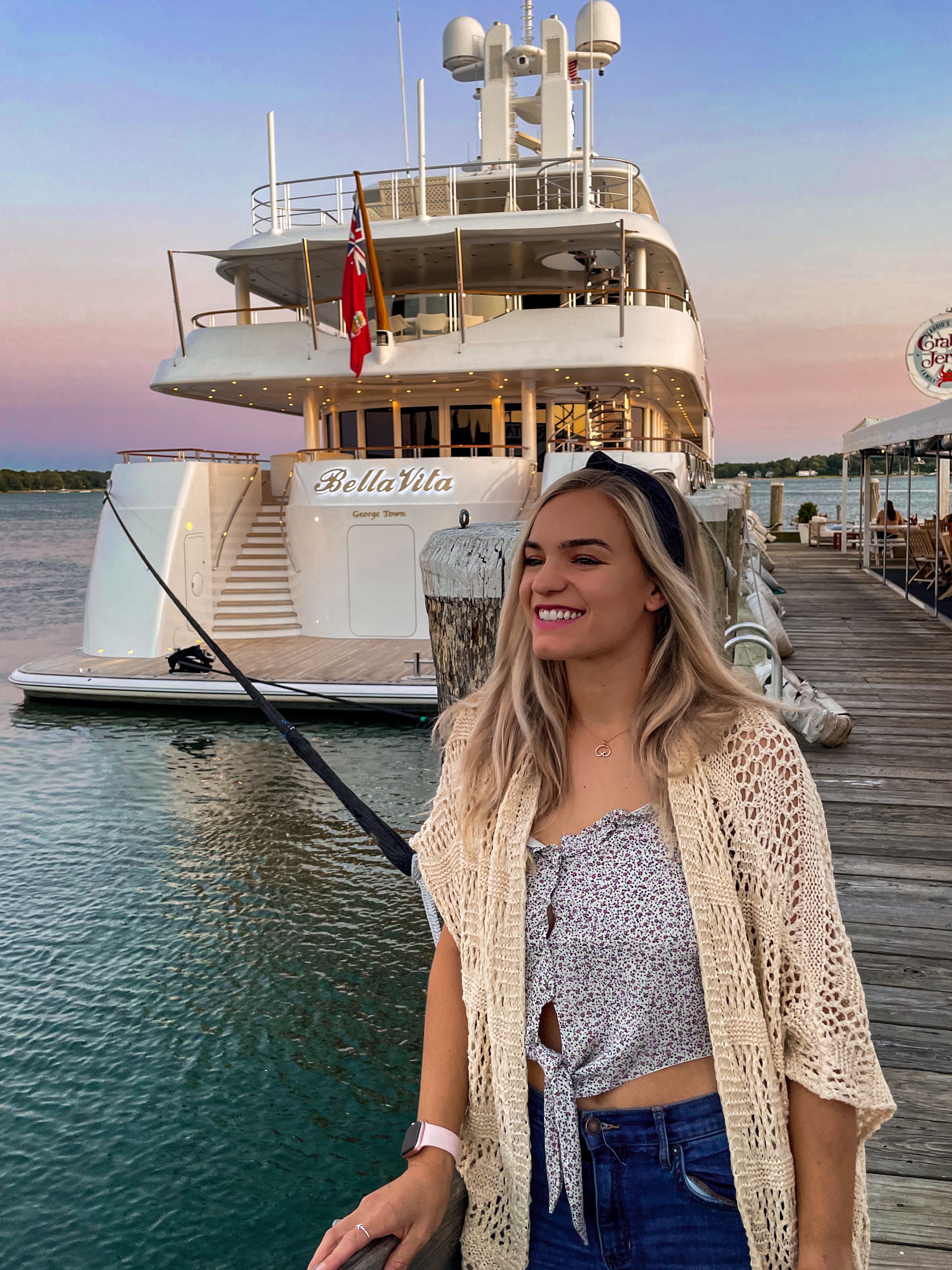 Young woman smiling on pier near luxury yacht marina, representing debt freedom and life change in Australia journey. Young woman smiling on pier near luxury yacht marina, representing debt freedom and life change in Australia journey.