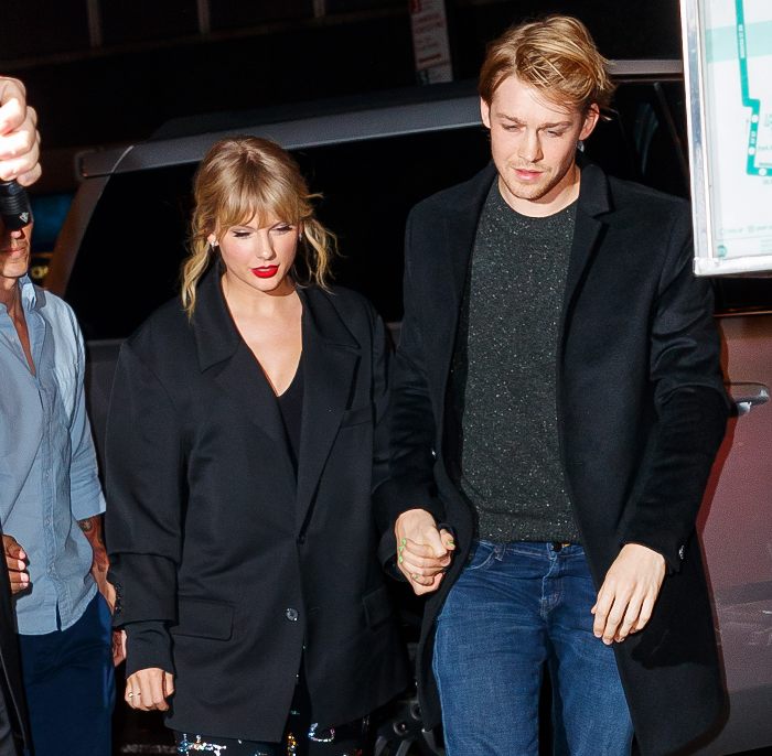 Taylor Swift and Travis Kelce holding hands at night, showcasing body language that stands out among past loves. Taylor Swift and Travis Kelce holding hands at night, showcasing body language that stands out among past loves.