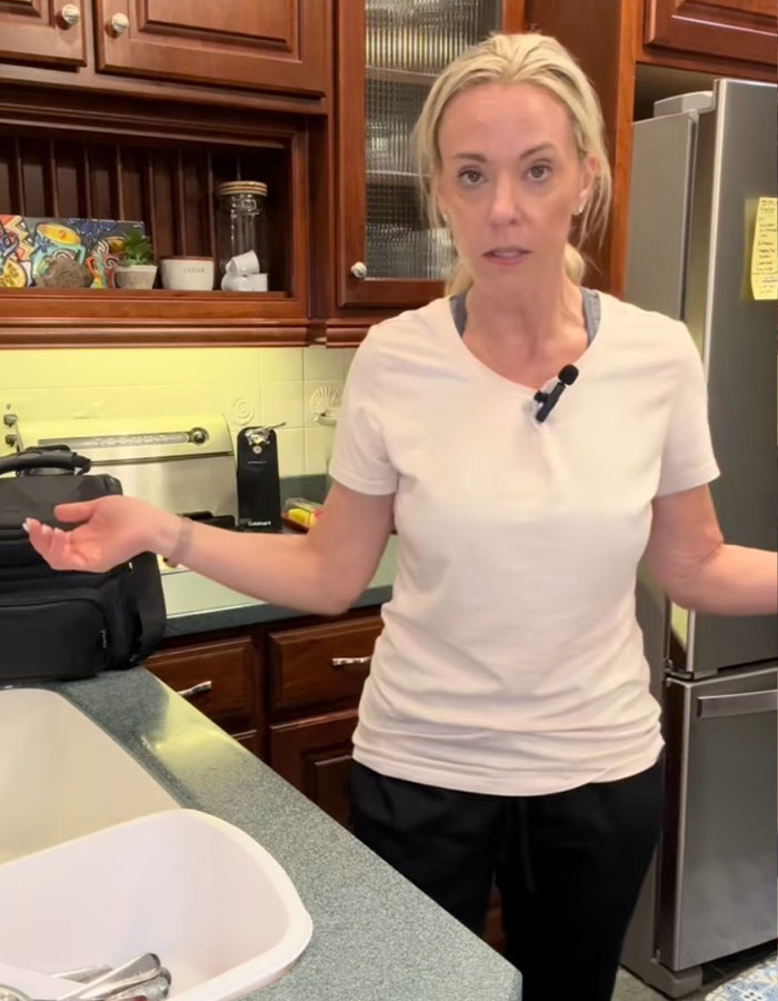 Reality star Kate Gosselin in a kitchen, wearing a white shirt, appearing concerned during a candid moment at home. Reality star Kate Gosselin in a kitchen, wearing a white shirt, appearing concerned during a candid moment at home.