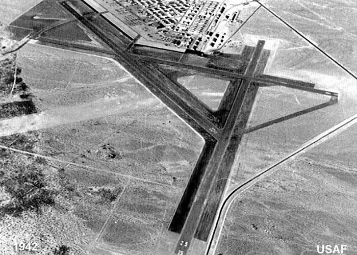 Aerial view of early Vegas airfield runway surrounded by desert landscape in historic 1942 photograph.