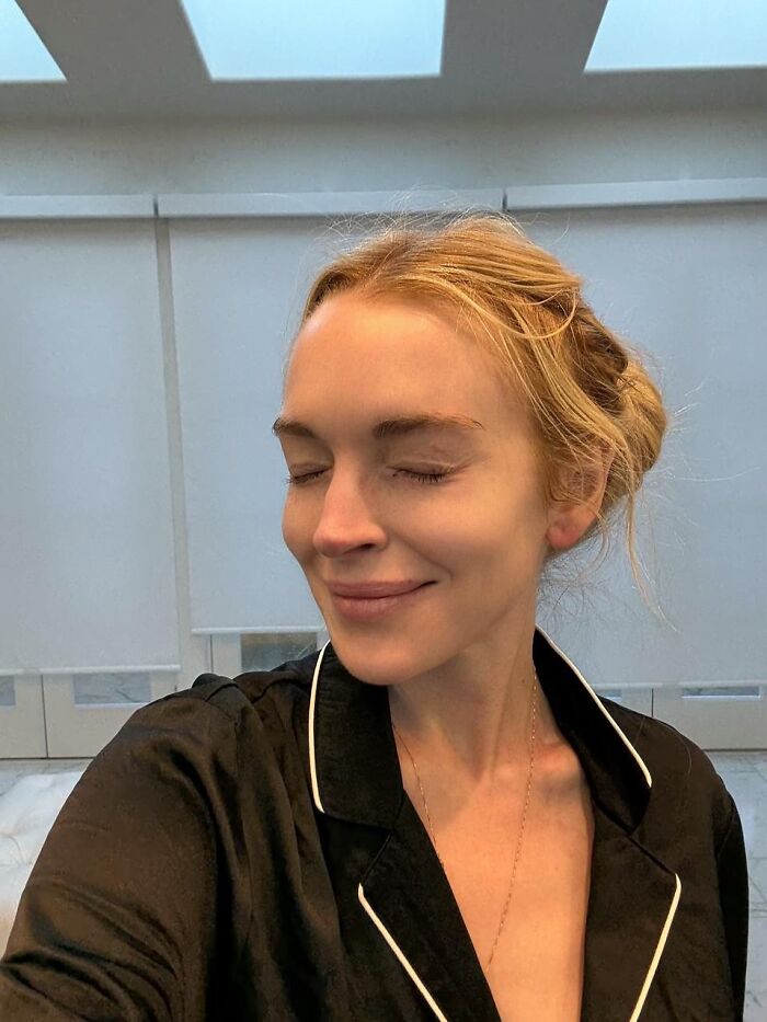 Lindsay Lohan in a makeup-free selfie, smiling with eyes closed, showing natural beauty after plastic surgery rumors. Lindsay Lohan in a makeup-free selfie, smiling with eyes closed, showing natural beauty after plastic surgery rumors.