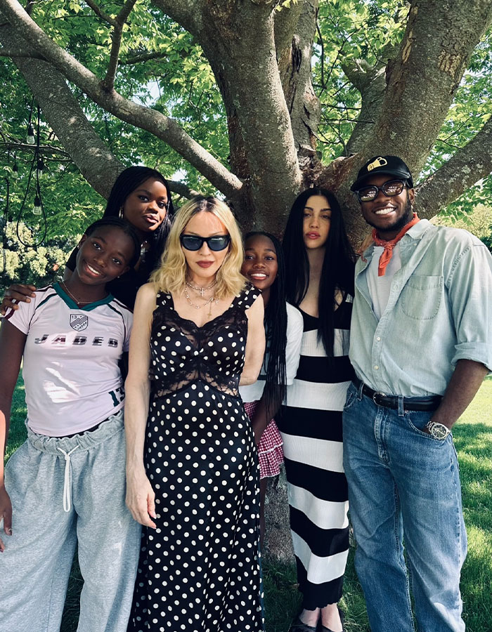 Madonna outdoors with friends under a tree, showcasing her style amid cosmetic change advice from her 29YO boyfriend. Madonna outdoors with friends under a tree, showcasing her style amid cosmetic change advice from her 29YO boyfriend.