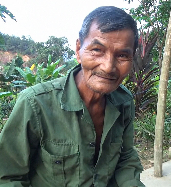 Elderly man outdoors in green jacket, smiling gently among lush plants, illustrating superhumans walking among us.