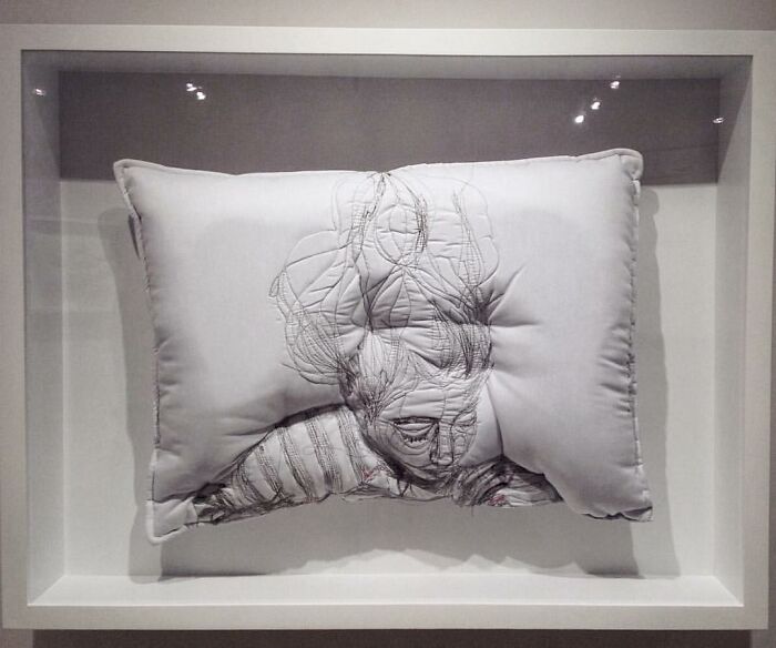 Embroidered pillow featuring abstract detailed face design capturing the dreamy beauty of sleep by Maryam Ashkanian.