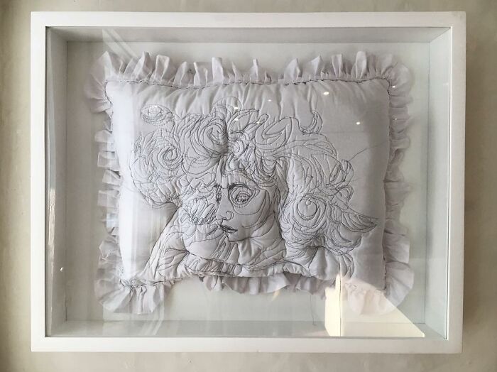 White embroidered pillow with detailed stitched portrait art, showcasing dreamy embroidery capturing the beauty of sleep.