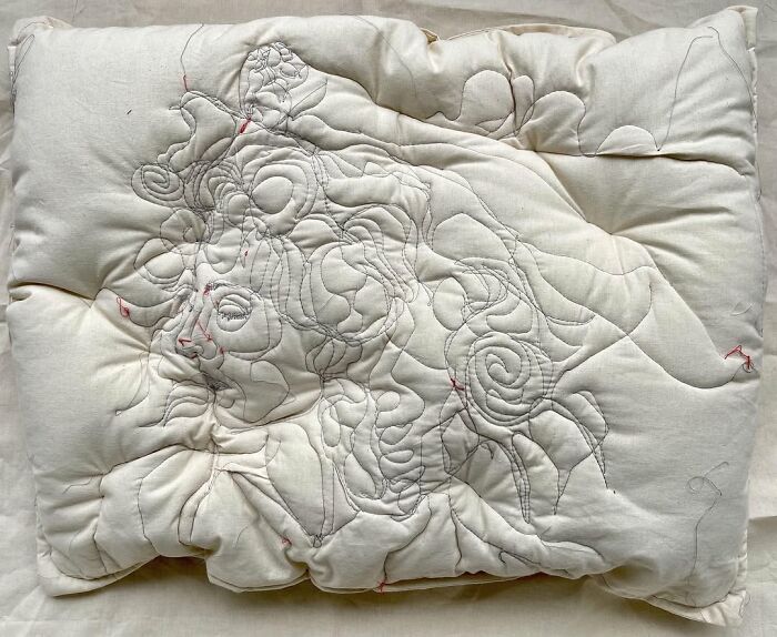 Embroidered pillow with abstract dreamy face design by Maryam Ashkanian showcasing the beauty of sleep and art.
