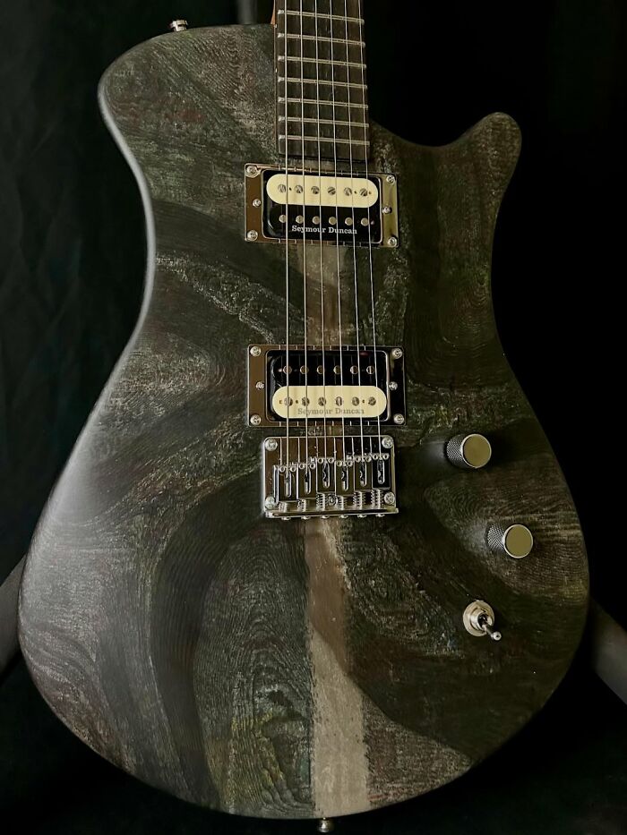 Electric guitar crafted using 3D mold technique with unique wood grain texture made from stacked newspapers.