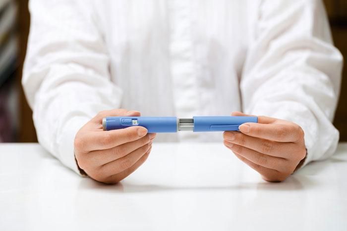 Person holding a blue medical injection pen, illustrating scientists' discovery of Ozempic's healthier rival with no side effects. Person holding a blue medical injection pen, illustrating scientists' discovery of Ozempic's healthier rival with no side effects.