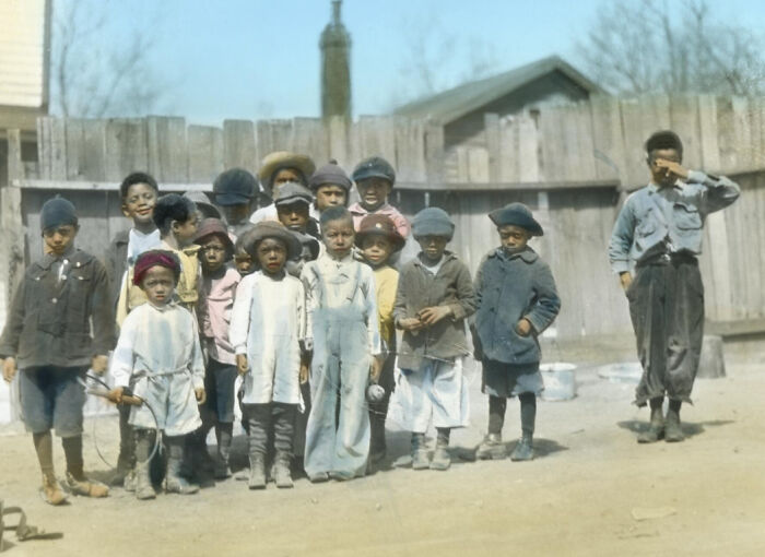 Group of African American children from the 1920s standing outdoors, showing the African American reality of the era.