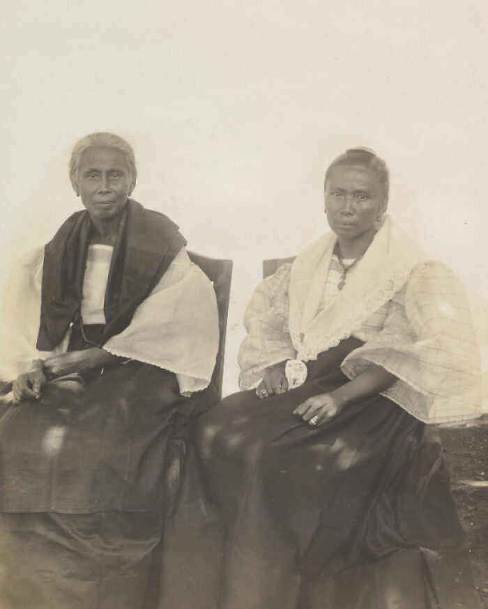 Two Filipino women in traditional 1890s clothing seated outdoors, reflecting the Philippines in the 1890s culture and fashion.
