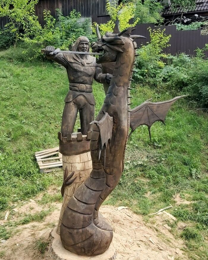 Chainsaw artist’s detailed wooden sculpture of a knight fighting a dragon, carved from a single forgotten tree.