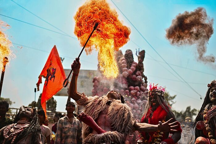 A vibrant fire breather performing during a colorful Indian festival, showcasing vivid photos of India filled with life.